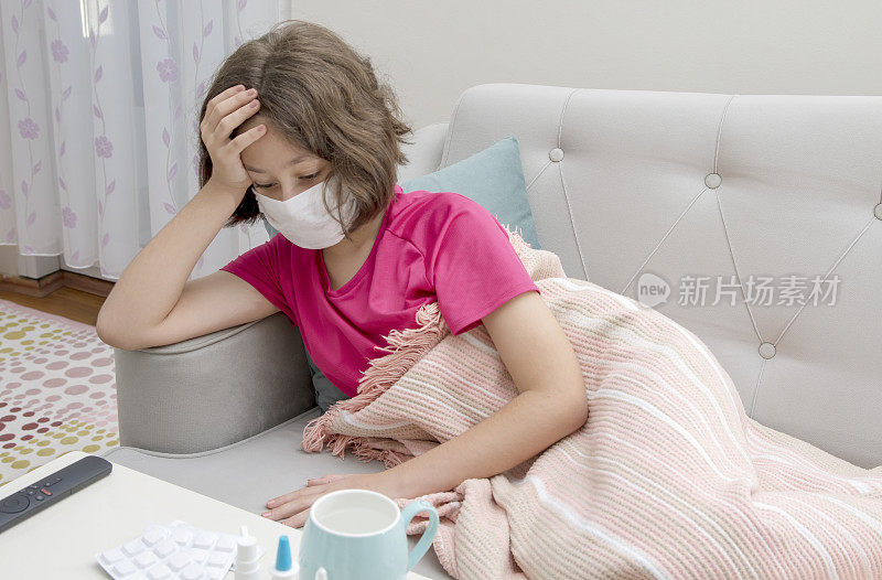 生病的年轻女孩躺在床上发高烧。Covid - 19和Cold flu库存照片